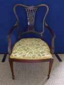 A Victorian mahogany elbow chair having tapered legs and spade feet to the front, splat back with