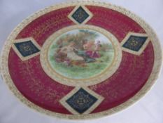 A large Viennese charger depicting a romantic scene of two figures in a garden, with gilded floral