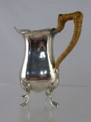 A Solid Silver Milk Jug, Sheffield hallmark, m.m Walker & Hall, the jug supported on claw feet, 200