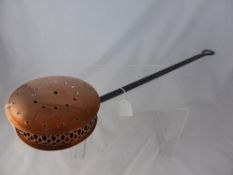 A vintage Copper Chestnut Roaster with wrought iron handle.