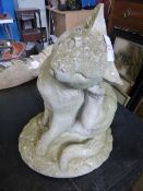 A composite stone garden figure, in the form of a seated cat.