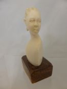 An Antique Carved Ivory Bust of a Nubian Woman, 8 cms high excluding stand.