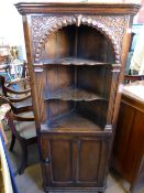 A Victorian oak corner cabinet having a decorative arched top with reeded decoration to the sides,