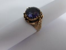 A Lady`s Dress Ring Set With a Single Alexandrite with fancy engraved shoulders stamped 9 carat,