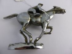 A vintage chrome Bonnet Mascot in the form of a jockey on horseback.