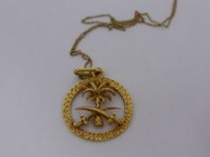 An 18 ct Gold Pendant and Chain, the circular pierced pendant depicting a desert palm and crossed