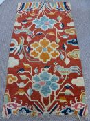 An Early Twentieth Century Tibetan Wool Rug depicting flowering trees, a Phoenix and cloud scrolls,