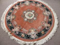 Circular Chinese Washed Rug, terracotta in colour with green floral design. 200 d.