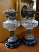 Pair of Antique Oil Lamps - ebonised base, copper support, glass oil bowl and brass burner to top,