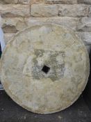 A Garden Stone Circular Table and One Bench, the table in the form of a millstone.