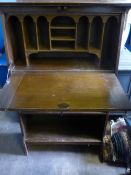 An Edwardian oak bureau fitted with pigeon holes to the interior and having two open shelves below,