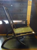 An antique colonial folding chair having a slatted back with Greek urn decoration to the centre and