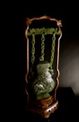 Chinese Marbled Deep Green Jade Suspended Vase and Cover, the baluster vase featuring a shallow