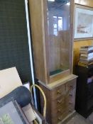 An antique pine cabinet having a glazed door to the top with four short and two long drawers below,