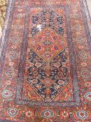 An Iranian wool carpet featuring an outside border of floral design with a central cartouche, the