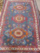 A Middle Eastern wool carpet having foliate design with floral border and being of blue, burgundy,