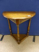 A reproduction oak hall table being D shaped on turned legs united by a triangular under shelf,