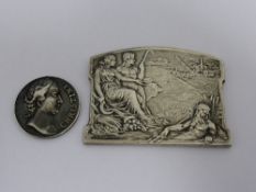 A silver plated medallion depicting Greek figures to one side with wording to back "" Obras desague