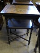 A small Edwardian oak folding games table having a red leather insert  with an under shelf on