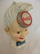 A 1950 Coca Cola Cast Iron Money Box depicting a jolly faced boy, 22 cms high.