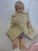Small Doll with bisque head, composite arms and legs. The open mouthed doll features small teeth,
