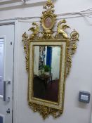 Gilt and plaster wall mirror, circa 1800, the frame being decorated with griffins and a miniature