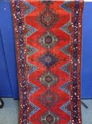 An Iranian cotton and wool runner having a red, blue and cream border with triangles to inside of