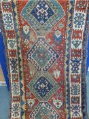 An Antique Heavy Woollen Caucasian Style Rug having five central ghouls with tribal pattern to