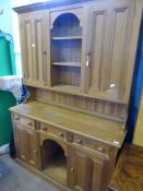 A vintage pine kitchen dresser having two cupboards and plate shelves to centre, three cutlery