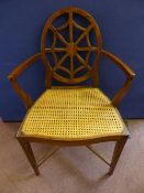 A rosewood cane seated cross banded occasional arm chair with web back design on tapered legs with
