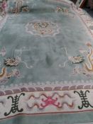 A Large Washed Chinese Carpet, the carpet having predominantly Celadon Green background depicting