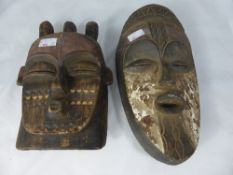 Two Carved Wooden West African `Galoa` Face Masks, hand painted, the first oval in shape depicting a