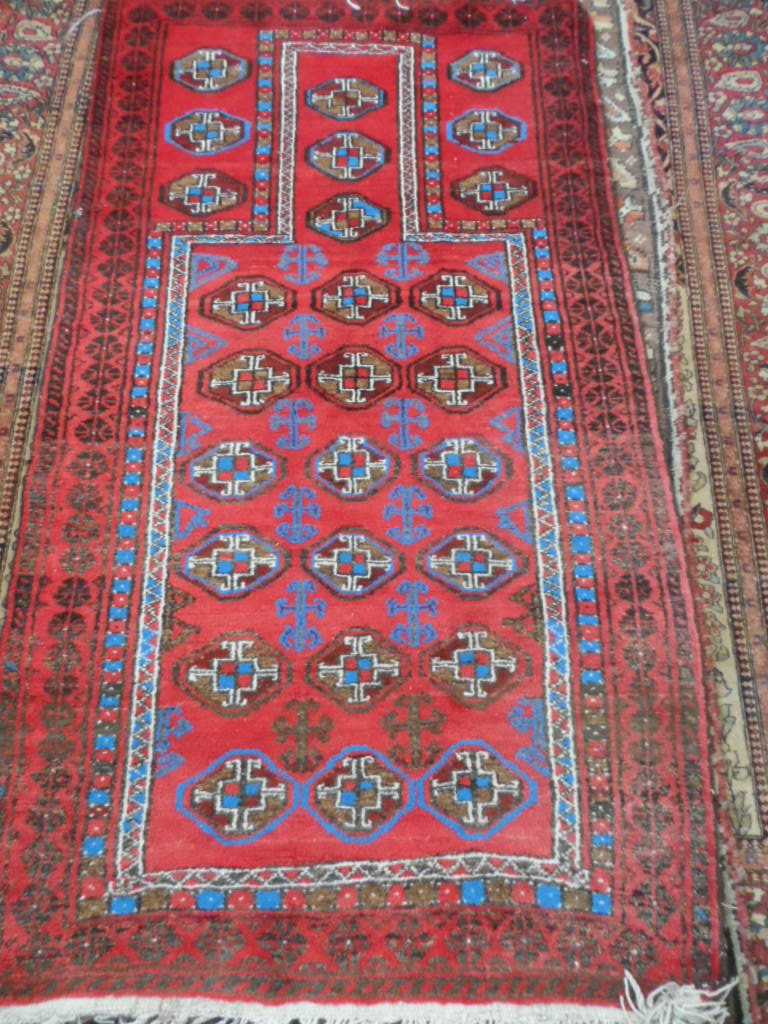 A Antique Middle Eastern Wool Prayer Rug, the rug having a burgundy background with bright blue