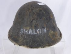 A Tin Artillery Helmet, with white stencilling the front of the helmet reads `Shalom` and the rear