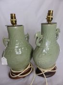 Two Celadon Green Lamp Bases, with raised Chinese inscription on a wooden base.