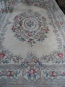 A large washed Chinese Carpet, the carpet having predominantly ivory background with rose and floral