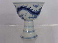 Chinese blue and white stem cup depicting chasing dragons with double rimmed design to splayed foot,