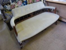 A Victorian salon settee with an open back with spindles and regency style motif and velvet