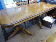 A reproduction extending pine breakfast table together with a set of six matching chairs having