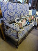 A Victorian high back Settee with turned and upholstered arm rests, the settee on turned legs and