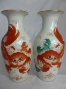 Pair of Chinese vases depicting lions with character marks to side, approx. 28 cms. high.