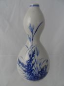 A Chinese blue and white double gourd vase, decorated with flowers with double rings to neck and