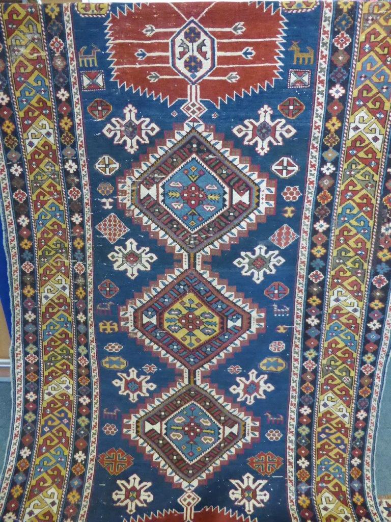 An Antique Caucasian Rug, the rug having five central ghouls with tribal motif to inner frieze,