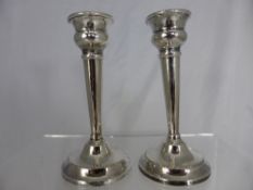 Pair of solid silver weighted candlesticks having beaded rim and base, Birmingham hallmarked,