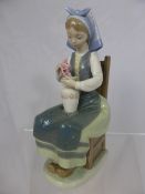 A Lladro Porcelain figure of a young lady arranging flowers, 20 cms high.