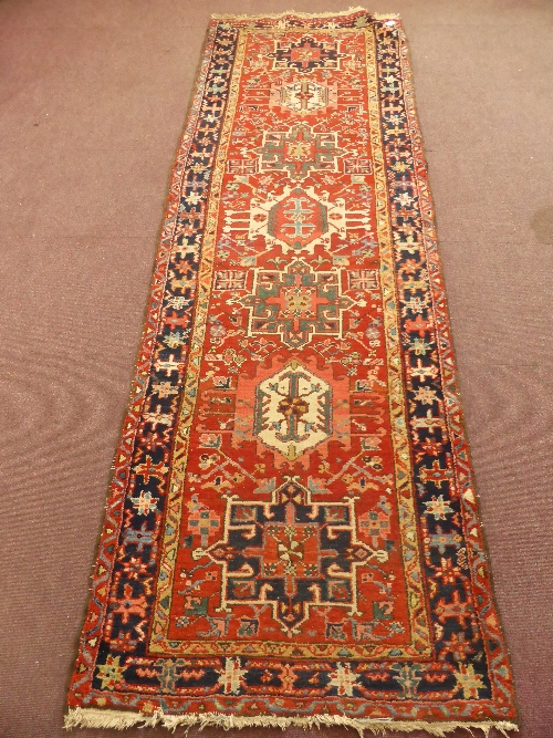 A Middle Eastern Hall Rug, geometric design, colourful red, blues and orange.