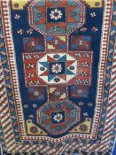 A Caucasian Style Carpet having three centrals ghouls with chevron design to border 159 x 109 cms.