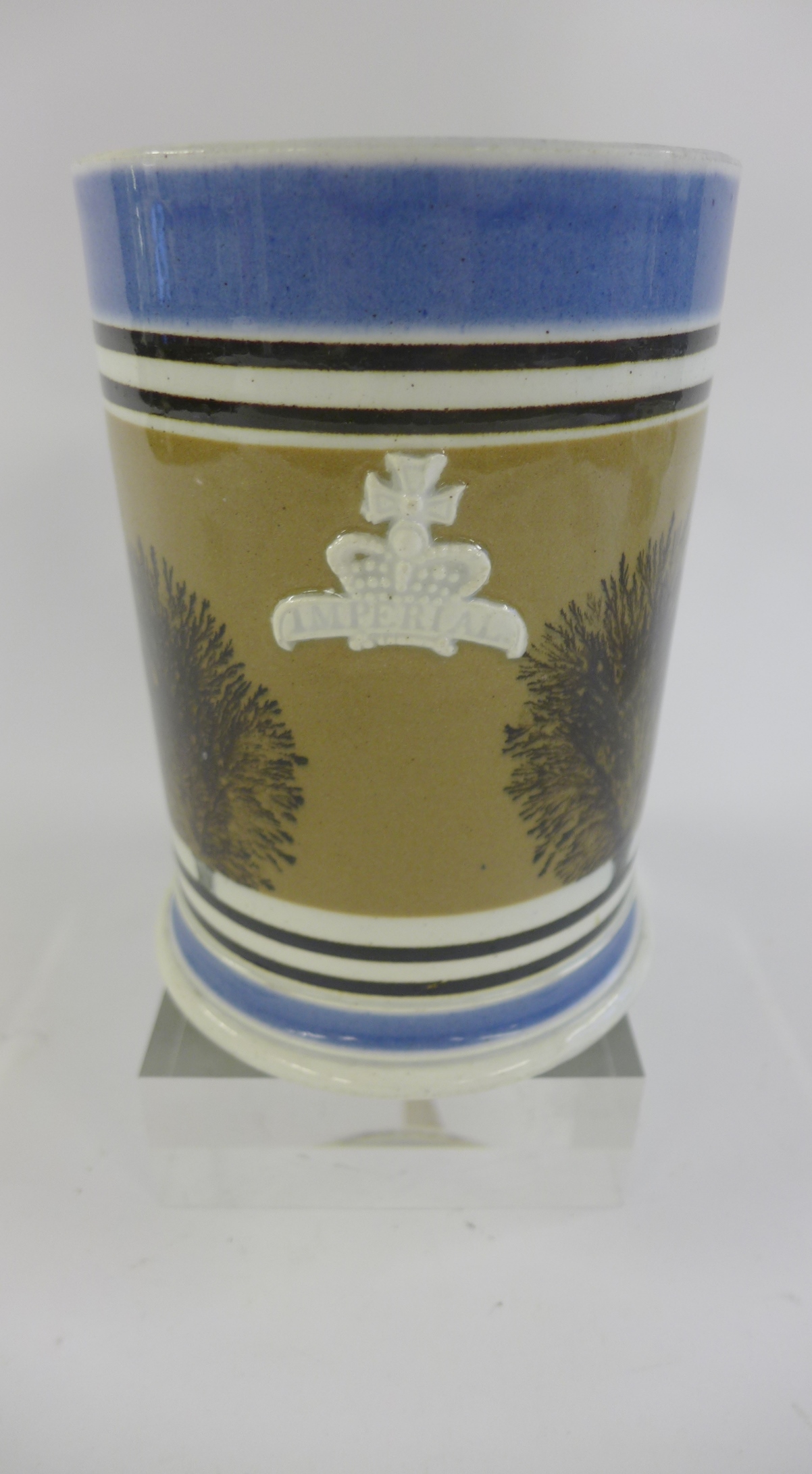 A 19th century Mocha Ware tankard typically decorated with sponged tree decoration to a painted and