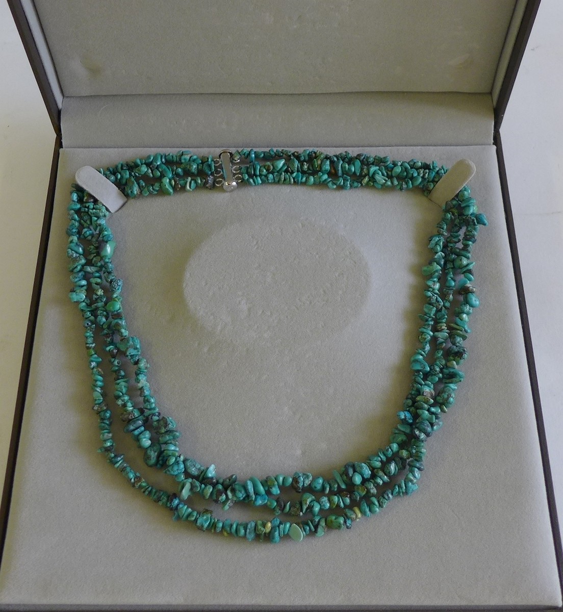 A triple strand turquoise matrix necklace with silver clasp in a fitted box