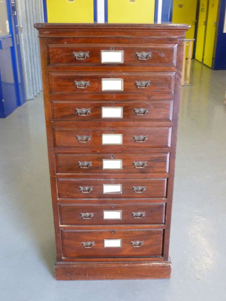 A Victorian mahogany eight drawer office chest with brass swing handles on pedestal base stamped